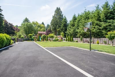 Spacious outdoor area with basketball court and greenery.