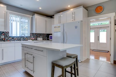 Modern kitchen area with an island and bar stools.