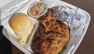 Plated meal with chicken, roll, and applesauce.