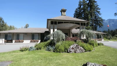 Exterior view of Riverside Manor surrounded by greenery.