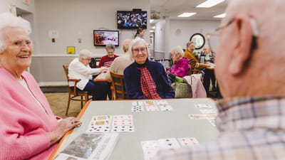 Residents playing cards in a common area.