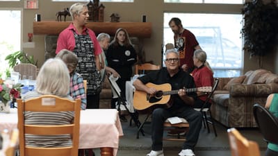 Residents enjoying a musical performance in a common area.