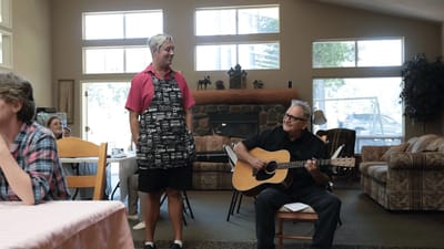 Musician performing for residents in a common area.