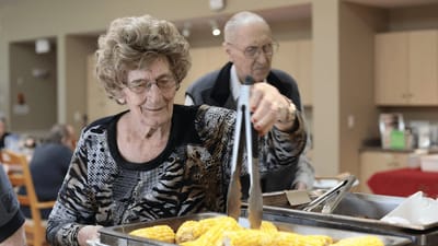 Resident enjoying a meal with staff assistance.