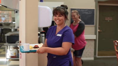 Staff member serving food in dining area