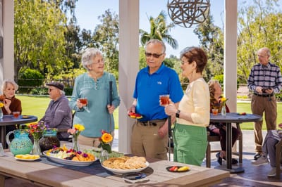 Residents enjoying a social gathering outdoors with refreshments.