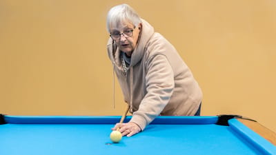Senior woman playing billiards indoors