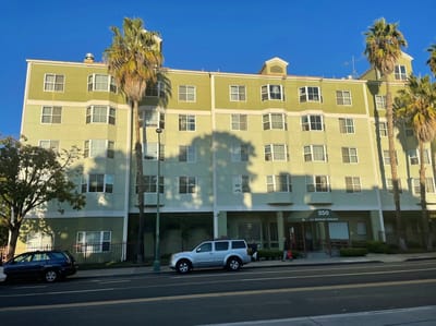 Exterior view of Hadley Villas building with palm trees.