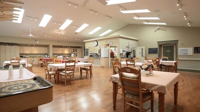 Bright dining room with tables set for meals.
