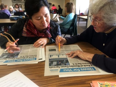Residents engaging in a newspaper reading activity