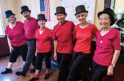 Residents enjoy a dance activity in red outfits.