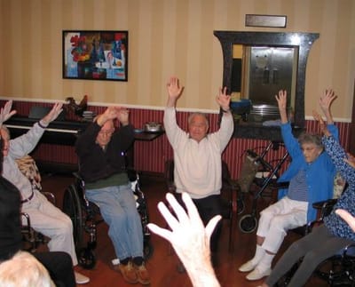 Residents participating in an activity with raised hands.