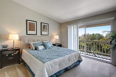 Cozy bedroom with natural light and balcony access.