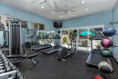 Gym area with exercise equipment and outdoor view.