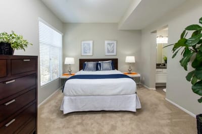 Well-furnished private resident room with bed and lamps.