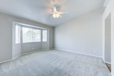 Empty living room with carpet and ceiling fan