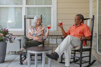Two residents enjoying drinks on a porch.