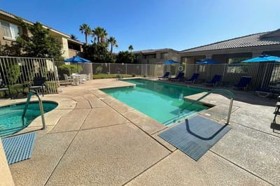Swimming pool area with lounge chairs and umbrellas