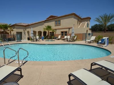 Outdoor pool area with seating and palm trees