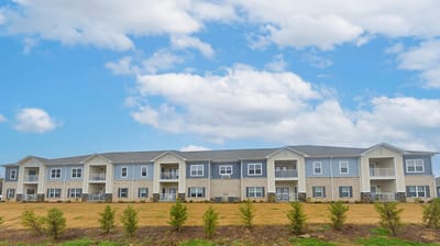 Exterior view of a senior living facility with blue sky