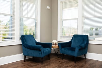 Cozy seating area with two blue chairs and a small table