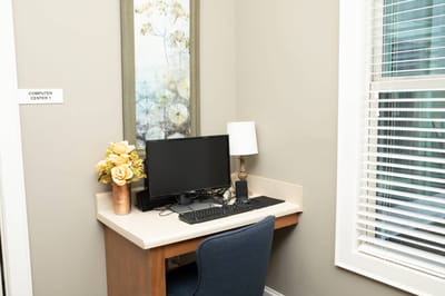 A nook with a computer and decorative flowers