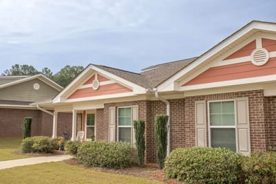 Exterior view of a senior living facility with landscaped garden
