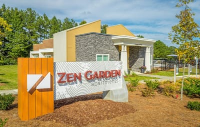 Exterior view of Zen Garden Apartments with signage