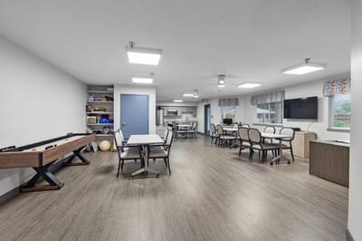 Bright activity room with seating and game tables
