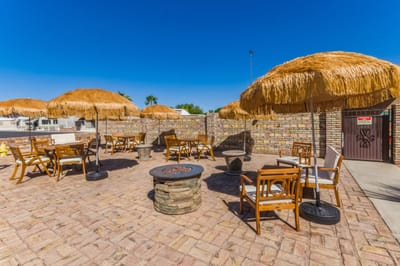 Outdoor patio area with seating and thatched umbrellas