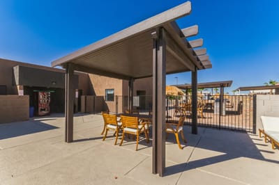 Outdoor shaded seating area with tables and chairs