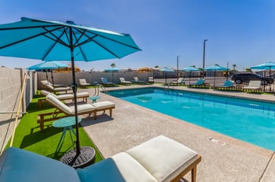 Outdoor pool area with lounge chairs and umbrellas