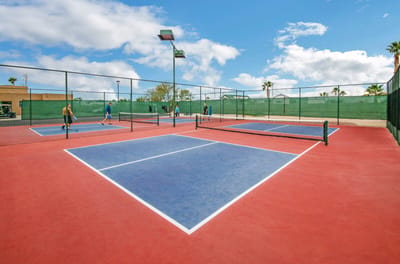 People playing tennis on outdoor courts