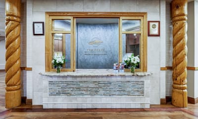 Reception area with a wooden desk and flowers