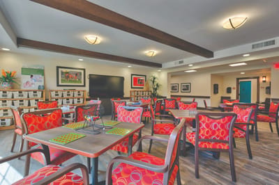 Bright common area featuring colorful seating and activity tables