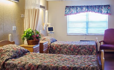 Cozy resident room with two beds and floral decorations