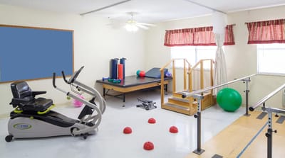 A bright exercise room with fitness equipment and colorful exercise balls