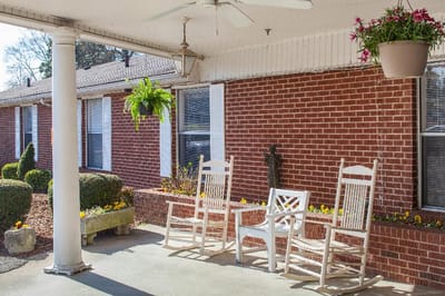 Outdoor rocking chairs with flower pots on a porch