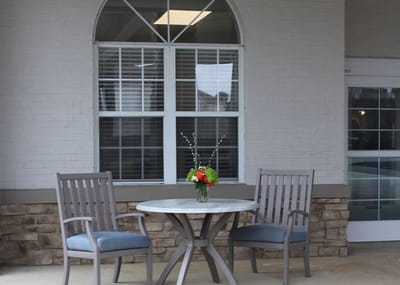 Outdoor seating area with a small table and flowers