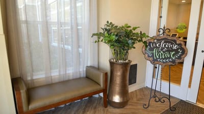 Welcoming lobby area with seating and a decorative sign
