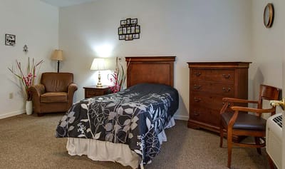 Cozy private resident room with a bed and chair