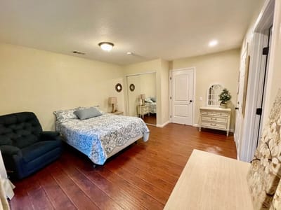 A bright and cozy resident room with a bed and chair