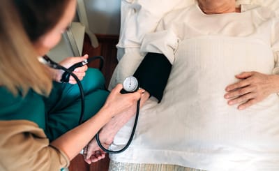 Healthcare provider monitoring a patient's blood pressure