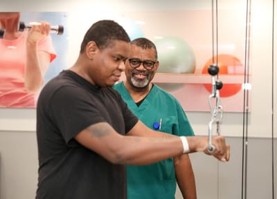 A staff member supporting a resident in a fitness activity