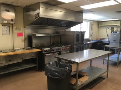 Commercial kitchen with cooking equipment and prep table
