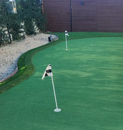 Putting green with flags in a landscaped area