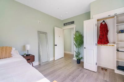 Brightly decorated private resident room with a bed and wardrobe