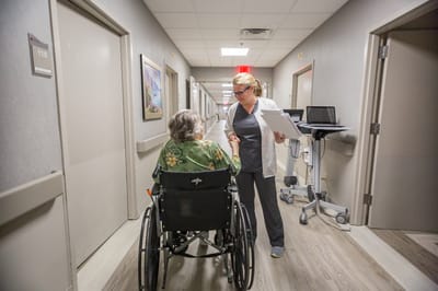 Staff assisting a resident in a hallway