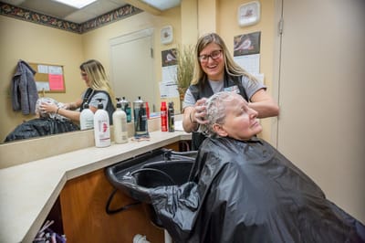 Staff member providing hair care to a resident