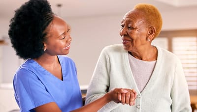 Staff member interacting with a resident in a bright room